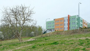 Tereny zielone dokoła szkoły, budynek szkoły na górce w oddali